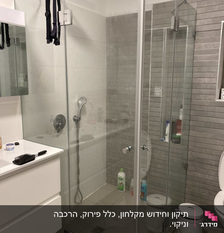 מקלחון זכוכית עם ראש מקלחת ומוצרי רחצה